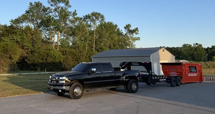 EZ Waste truck towing a dumpster trailer at sunset
