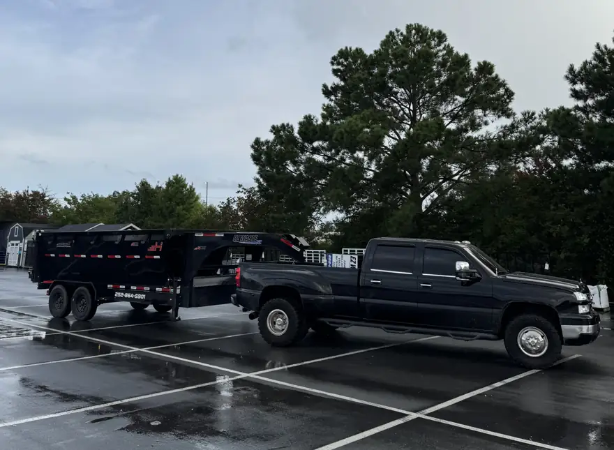 EZ Waste truck hauling a dumpster in the rain